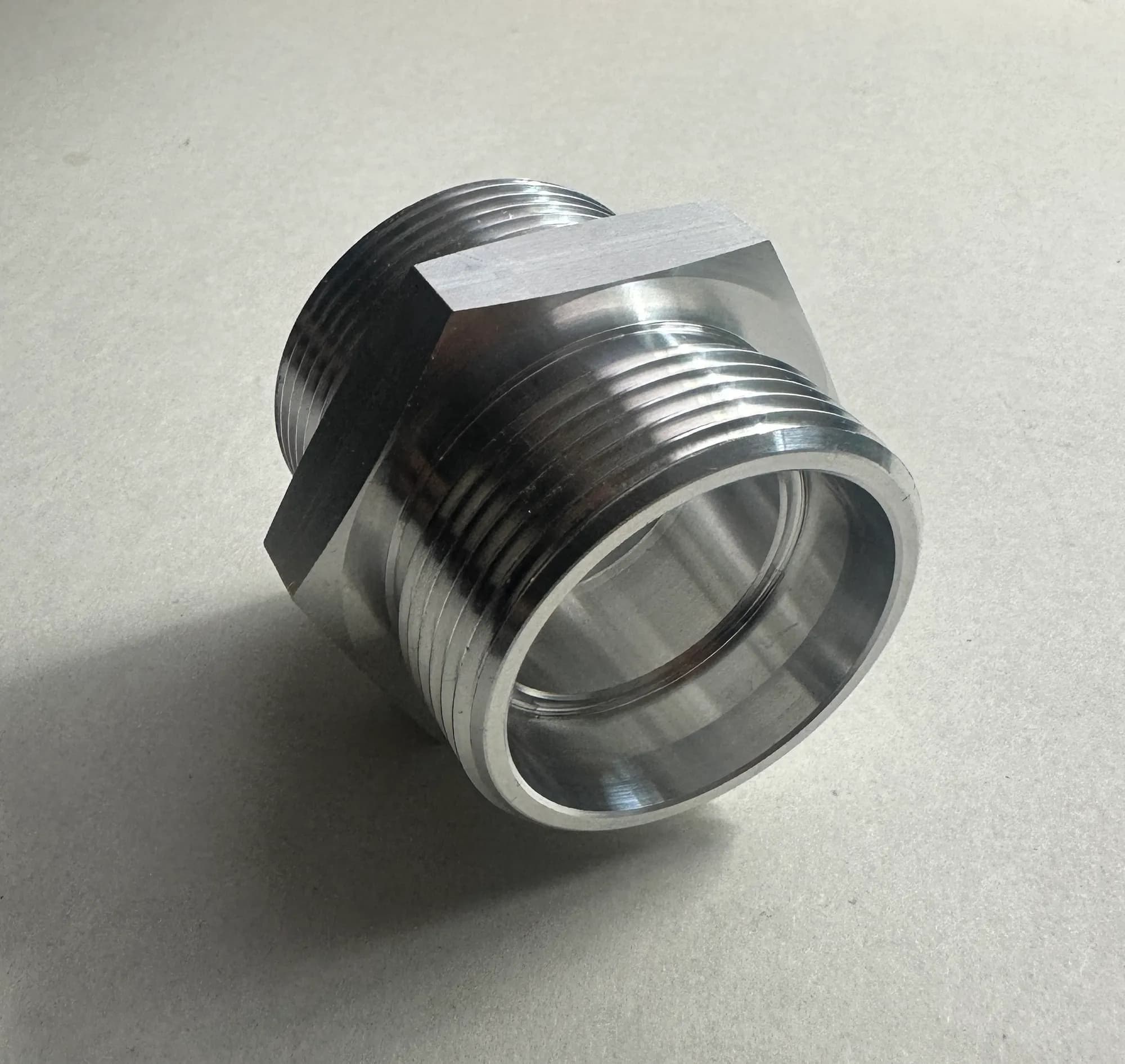 Precision CNC turned aluminum hex fitting machined at Kohler and Clark