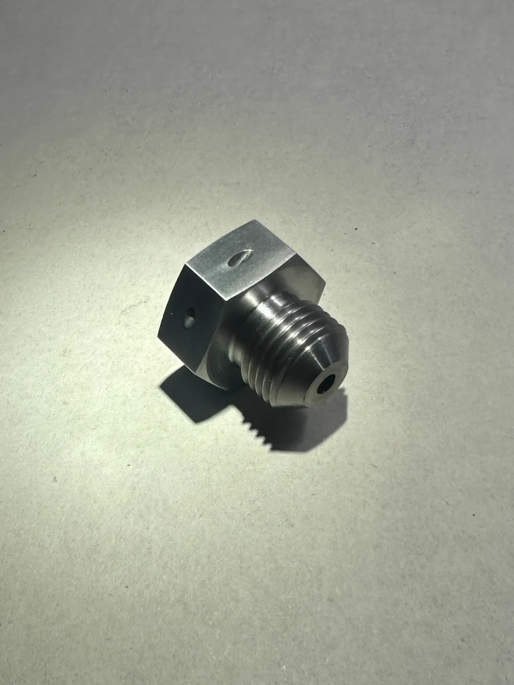 Precision aerospace hex fitting with bore hole manufactured by Kohler and Clark